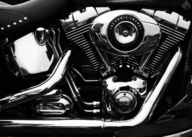 Harley Davidson Soft Tail in black and white. Cropped in to engine. High contrast emphasis on bright chrome work, by Denis Taylor